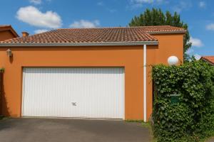 a white garage door in front of a house at Casa Vixoi, a 5Km Catedral in Santiago de Compostela