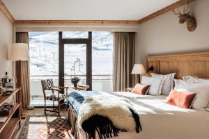 a bedroom with a bed and a large window at Alpes Hôtel du Pralong in Courchevel +77 photos