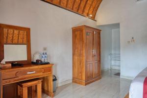une chambre avec une commode en bois et une armoire en bois dans l'établissement Alit Cottage, à Nusa Penida