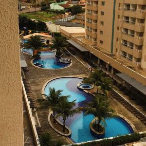 an overhead view of three swimming pools with palm trees at ENJOY OLIMPIA PARK RESORT - Thermas dos Laranjais in Olímpia
