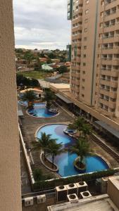 arial view of three pools with palm trees and buildings at ENJOY OLIMPIA PARK RESORT - Thermas dos Laranjais in Olímpia