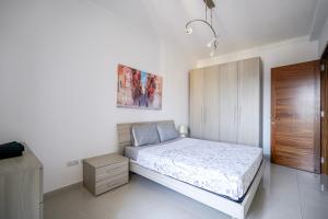 a bedroom with a bed and a wooden cabinet at Spacious Seafront 3-Bedroom Apartment in Sliema SV 3 in Sliema