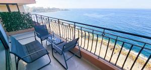 two chairs and a table on a balcony overlooking the ocean at Spacious Seafront 3-Bedroom Apartment in Sliema SV 3 in Sliema