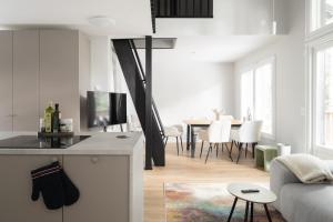 a kitchen and living room with a couch and a table at Villa MiaEmilia B in Espoo