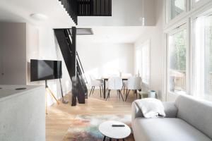 a white living room with a couch and a table at Villa MiaEmilia B in Espoo