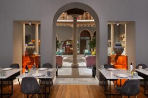 ウベダにあるHotel Don Juan Boutiqueのダイニングルーム(テーブル、椅子、花瓶付)