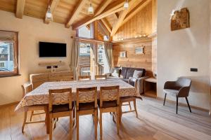 Un comedor con una mesa y un televisor. en Livigno Wooden House, en Livigno
