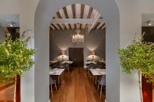une salle à manger avec tables et chaises et un lustre dans l'établissement Hotel Don Juan Boutique, à Úbeda