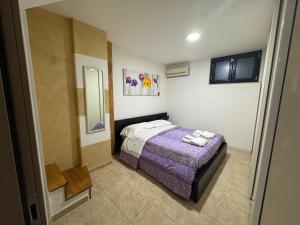 a small bedroom with a bed and a mirror at Casa Vacanze Ginevra & Carlotta Villaggio RIVAZZURRA POLICORO in Policoro +48 photos