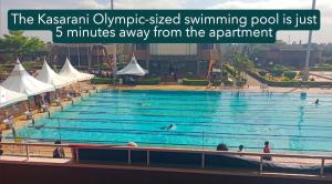 ein großes Schwimmbecken mit Menschen, die darin schwimmen in der Unterkunft Tsavo Royal Suburb - blossom homes in Nairobi