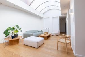 a living room with a couch and tables and a skylight at Hôtel Porte Mars - Reims Gare Centre Arena in Reims