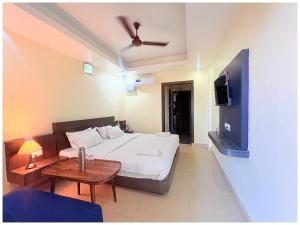 a bedroom with a bed and a table and a tv at Rooftop Sea View Hotel The Shivalik Premium Deep Ganga Inn Near Jagannath Temple- Lift # Parking Facility # Fully Air Conditioning Premium Rooms-Best Premium Hotel In Puri in Puri