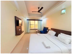 a hotel room with a bed and a chair at Rooftop Sea View Hotel The Shivalik Premium Deep Ganga Inn Near Jagannath Temple- Lift # Parking Facility # Fully Air Conditioning Premium Rooms-Best Premium Hotel In Puri in Puri +15 photos