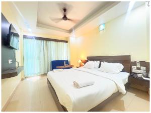 a bedroom with a large bed and a television at Rooftop Sea View Hotel The Shivalik Premium Deep Ganga Inn Near Jagannath Temple- Lift # Parking Facility # Fully Air Conditioning Premium Rooms-Best Premium Hotel In Puri in Puri