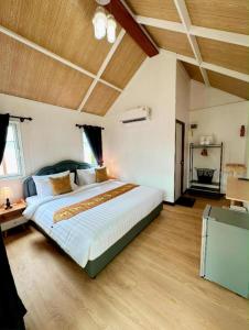 - une grande chambre avec un grand lit et des plafonds en bois dans l'établissement The white resort & restaurant koh yao yai, à Ban Khlong Hia