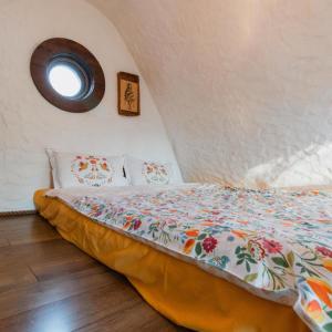 a bed in a room with a round window at Căsuțele de sub Șipote in Porumbacu de Sus