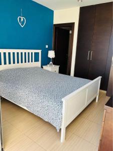 a bedroom with a large bed with a blue wall at Paradise Apartment in Protaras