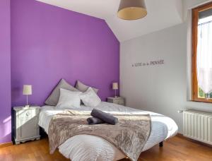 a bedroom with purple walls and a large bed at La Saint Joseph in Compiègne