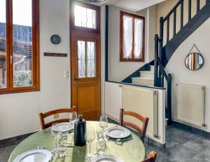 a dining room with a table and chairs and a staircase at La Saint Joseph in Compiègne