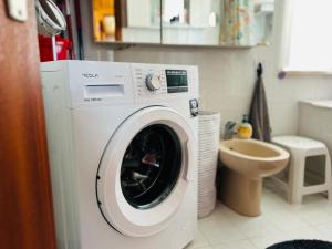 a white washing machine in a bathroom with a toilet at House for nature lovers in Medvode +22 photos