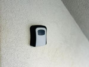 a black and white button on a white wall at House for nature lovers in Medvode