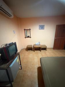 a living room with a tv and a couch at อู๊ดดี้บริการห้องพัก in Nong Prue