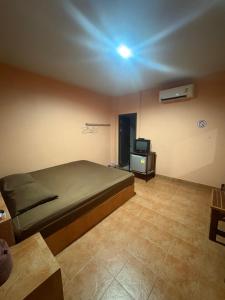 a bedroom with a bed and a tv in it at อู๊ดดี้บริการห้องพัก in Nong Prue