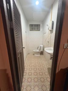 a bathroom with a toilet and a sink at อู๊ดดี้บริการห้องพัก in Nong Prue
