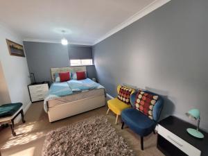 a bedroom with a bed and a chair and a rug at Modern Apartment in Luton in Luton