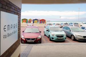 un grupo de coches estacionados en un estacionamiento cerca de la playa en Surfers Empire Penthouse, en Muizenberg