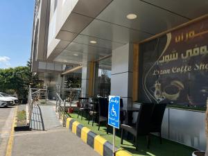 a restaurant with tables and chairs in front of a building at Lamasat Al Ajnaha Serviced Apartments in Abha