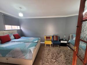 a bedroom with a bed and two chairs at Modern Apartment in Luton in Luton +11 photos