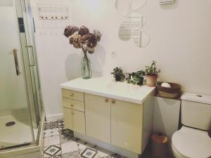 ein Badezimmer mit Waschbecken und einer Blumenvase in der Unterkunft Au Ptit Gauguin in Pont-Aven