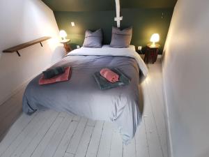 ein Schlafzimmer mit einem großen Bett mit zwei Kissen darauf in der Unterkunft Au Ptit Gauguin in Pont-Aven