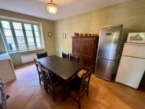 a kitchen with a table and a refrigerator at Charmante maison à Laure-Minervois avec piscine et jardin in Laure-Minervois