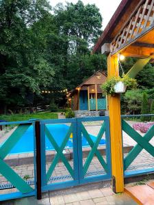 a wooden fence with a pool in front of a house at FoRResT in Chynadiyovo