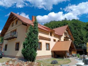une maison avec un arbre devant dans l'établissement Chata Dolinka Gápel, à Valaská Belá