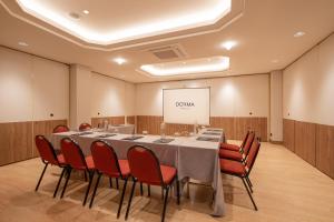 a conference room with a table and chairs and a screen at Dorma Sardinero in Santander