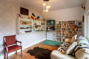 a living room with a couch and book shelves at Pensiunea Popas Pop, Strambu-Baiut, Maramures in Băiuţ