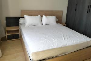 a bedroom with a large bed with white sheets and pillows at 2 Bed Chalet Sleeps 4 Free Parking & Balcony in Ain Sokhna