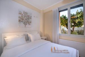 a bedroom with a white bed and a window at Villa Arancia in Pigi +127 photos