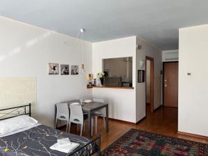 OTB Italia 1 - Luminoso appartamento tra Venezia e Treviso con Terrazza e Posto auto Coperto في بريغانزيول: غرفة نوم بها سرير وطاولة وكراسي