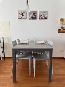 OTB Italia 1 - Luminoso appartamento tra Venezia e Treviso con Terrazza e Posto auto Coperto في بريغانزيول: طاولة طعام مع كراسي وطاولة رمادية +9 صور