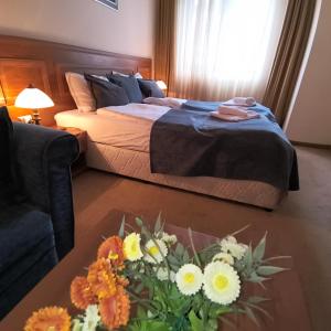 ein Schlafzimmer mit einem Bett und einem Tisch mit Blumen in der Unterkunft Ski view suite Emerald Bansko in Bansko