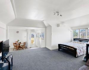 a bedroom with a bed and a dining room with a table at Giggly Nest in New Plymouth