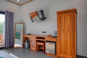 Alit Cottage في نوسا بينيدا: غرفة مع مكتب خشبي ومرآة