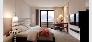 a bedroom with a large bed and a desk and a window at VILLA OXA - Boutique Design Hotel in Maria Alm am Steinernen Meer +105 photos