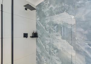 ein Bad mit einer Dusche und einer Marmorwand in der Unterkunft Pristine Modern Cottage with Tennis & Laundry in Johannesburg + 51 Fotos