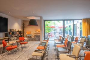 a waiting room with a bunch of chairs and tables at L'Imprimerie Hôtel in Clichy
