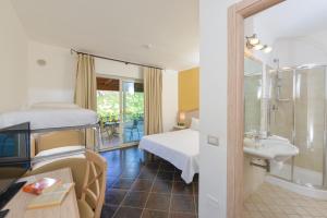 a bedroom with a bed and a bathroom with a sink at Castelsardo Resort Village in Castelsardo +46 photos